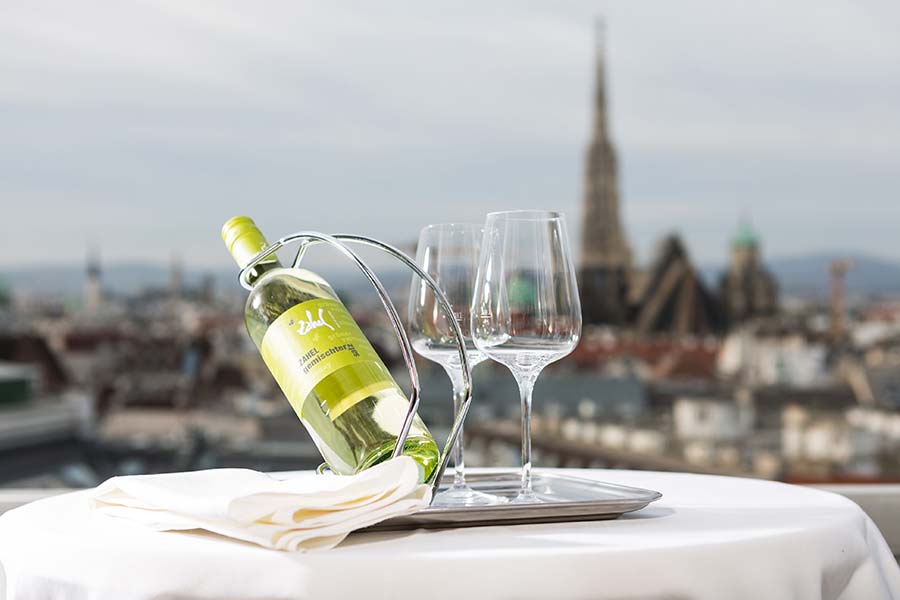 Urlaub in Wien Eine Flasche Weißwein und zwei Gläser steht auf der Terrasse